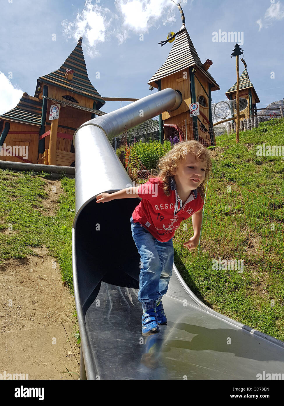 Heureusement Garçon jouant sur une aire de jeux dans les montagnes Banque D'Images