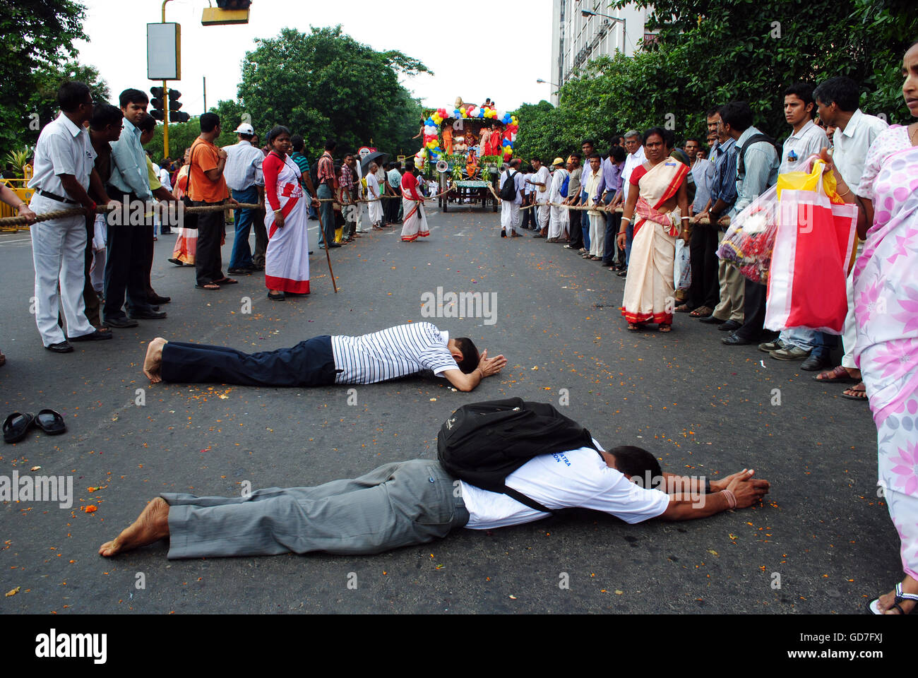 Les dévots sont couchés sur la route pour rendre hommage à Lord Jagannath, dieu Hindou, dans le Rath Jatra à Kolkata, W B , en Inde. Banque D'Images