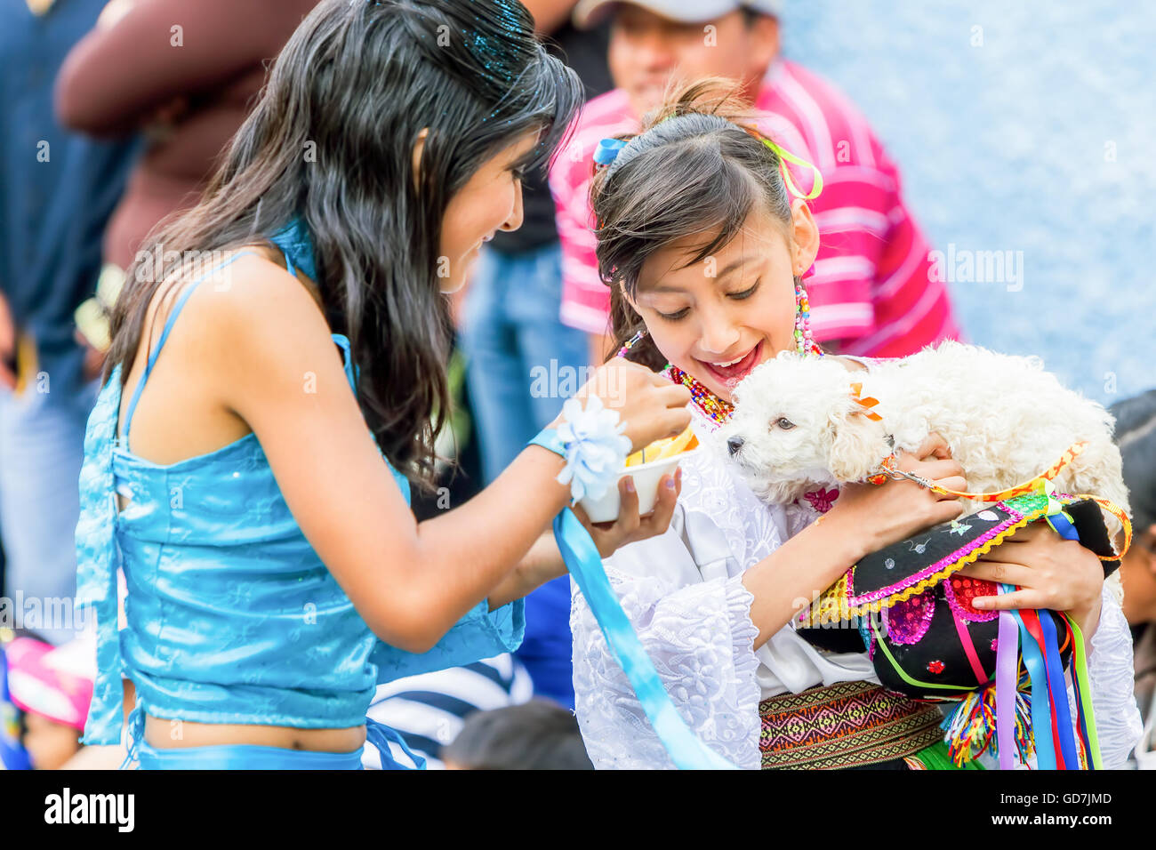 Banos de Agua Santa - 29 novembre : Deux jeunes filles vêtues de costumes folkloriques équatorienne de nourrir un chiot dans la rue Banque D'Images