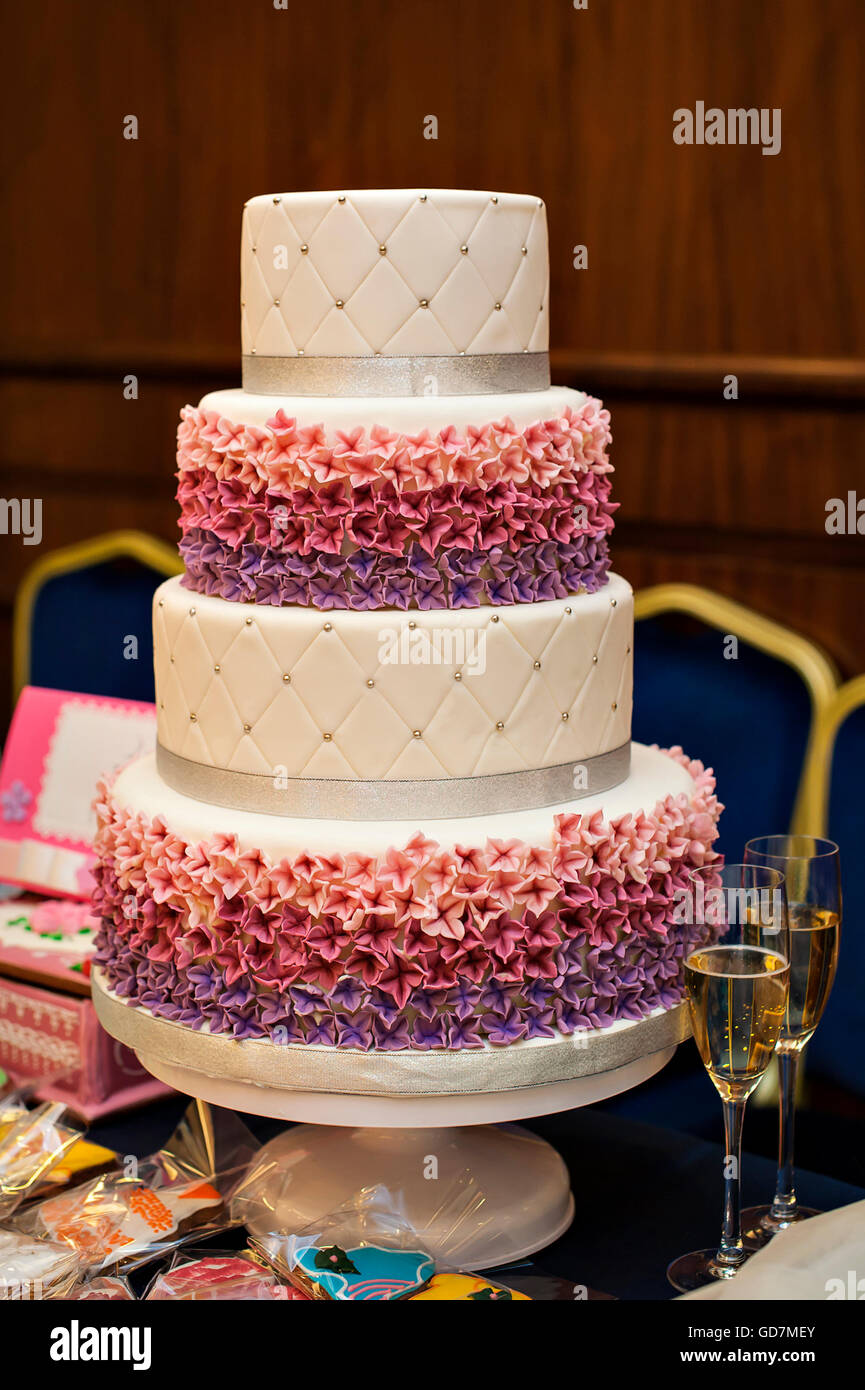White multi niveau gâteau de mariage avec des décorations de fleurs roses Banque D'Images