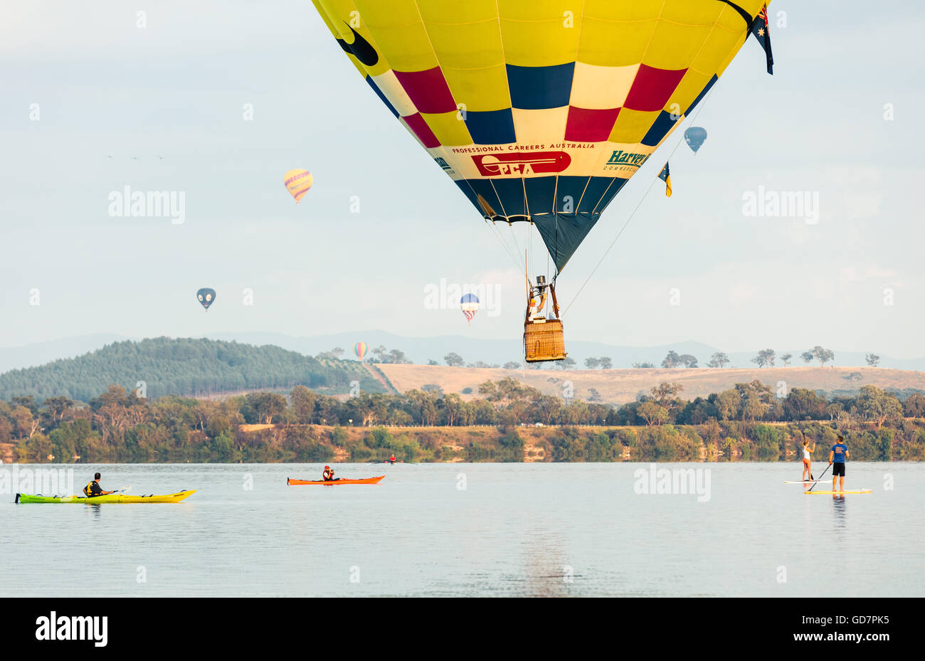 Les canoéistes et paddleboarders rencontrez un ballon à air chaud comme il l'écumage lac Burley Griffin au ballon de Canberra 2016 spectaculaire Banque D'Images