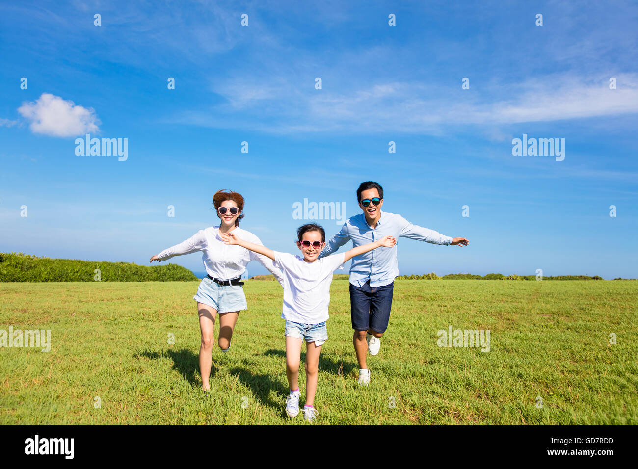 Happy Family running ensemble sur l'herbe Banque D'Images