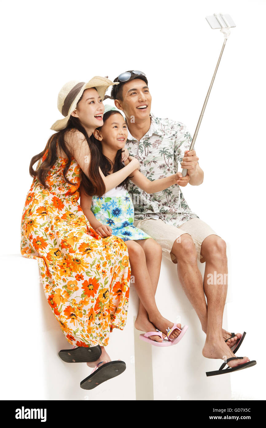 Le bonheur d'une famille de trois personnes avec un téléphone mobile retardateur Banque D'Images