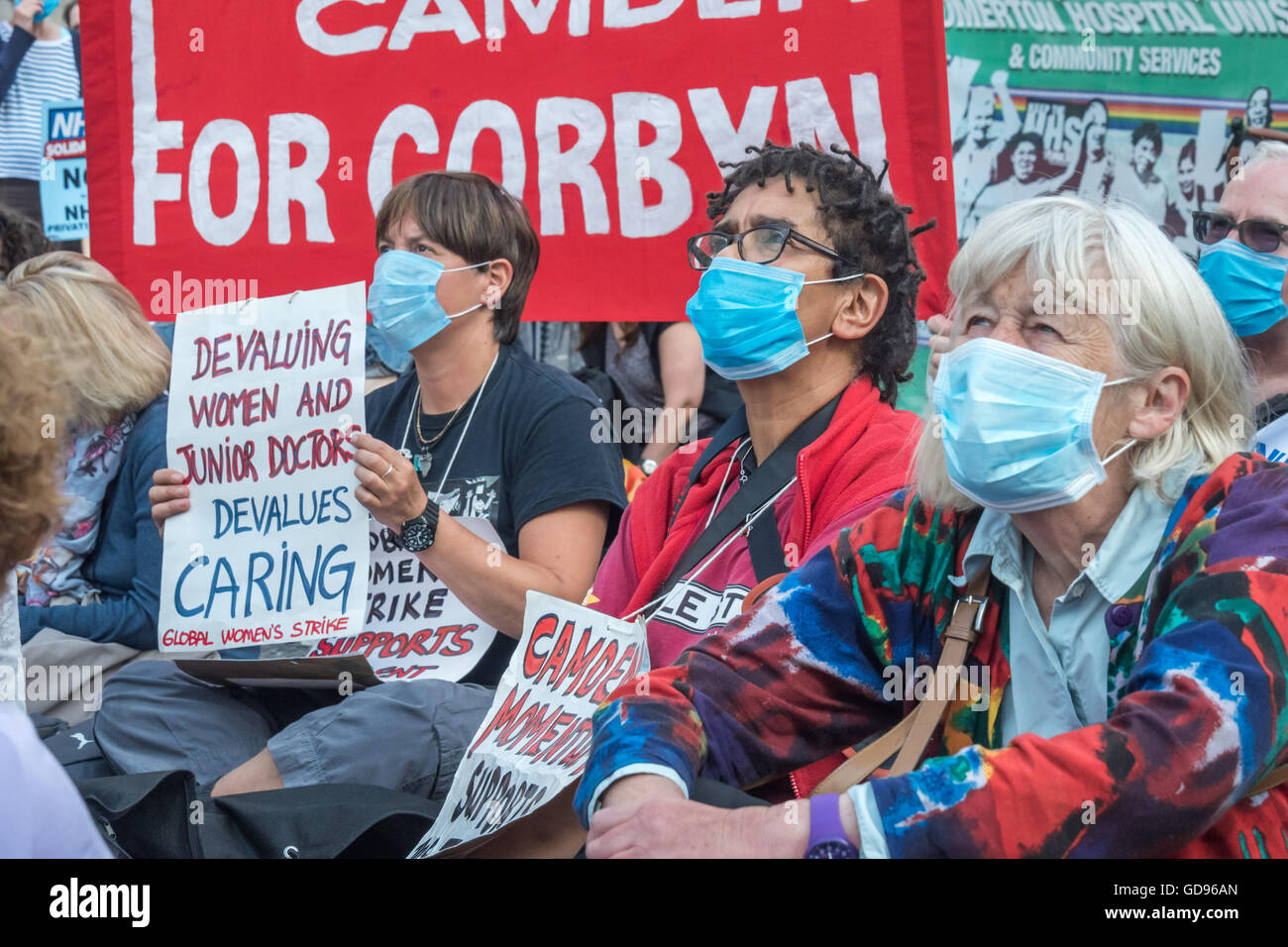 Londres, Royaume-Uni, le 14 juillet 2016. Les travailleurs de la santé et de supports dédiés à la sauvegarde d'un système public, livré et responsable d'usure du NHS masques chirurgicaux et de s'asseoir sur la route à l'extérieur de l'Hôpital St Bartholomew's avant leur courte mars derrière le feu de moteur FBU de St Paul. L'événement était organisé par la solidarité du NHS. Peter Marshall/Alamy Live News Banque D'Images