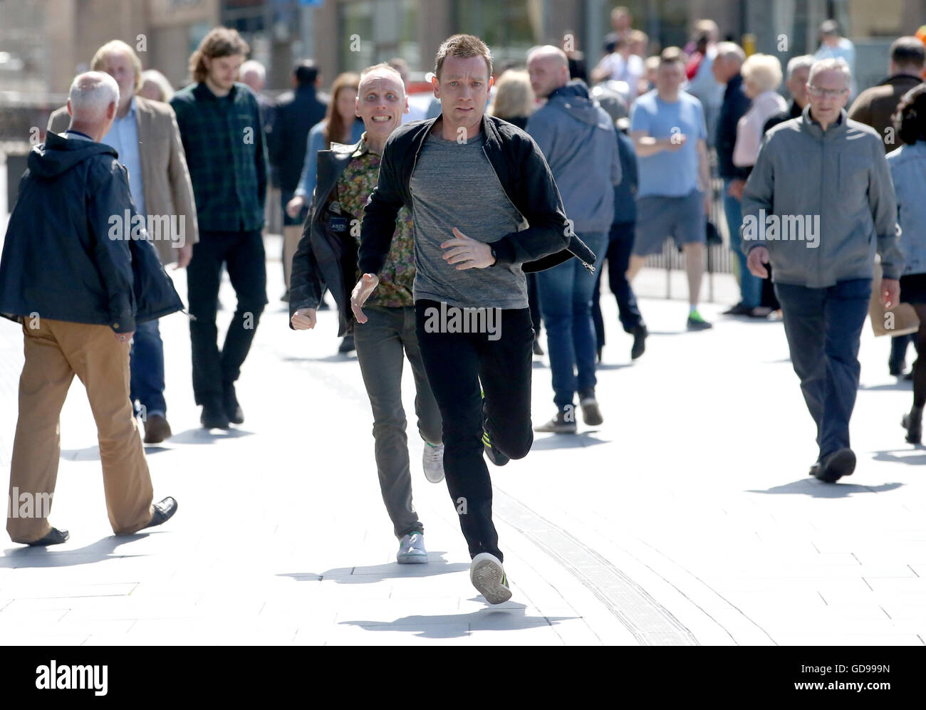 Les acteurs Ewan McGregor (avant) et Ewan Bremner (derrière) en marche à travers les rues d'Édimbourg où des scènes du nouveau Trainspotting 2 est en tournage. Banque D'Images