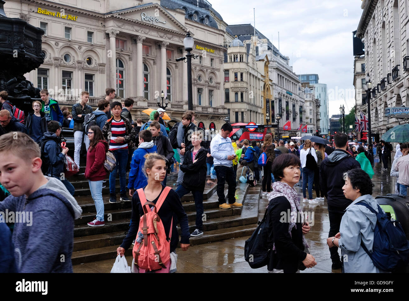 London Piccadilly Circus. Les touristes, debout sur le perron de l'éros dans Piccadilly Circus London sur un jour de pluie Banque D'Images