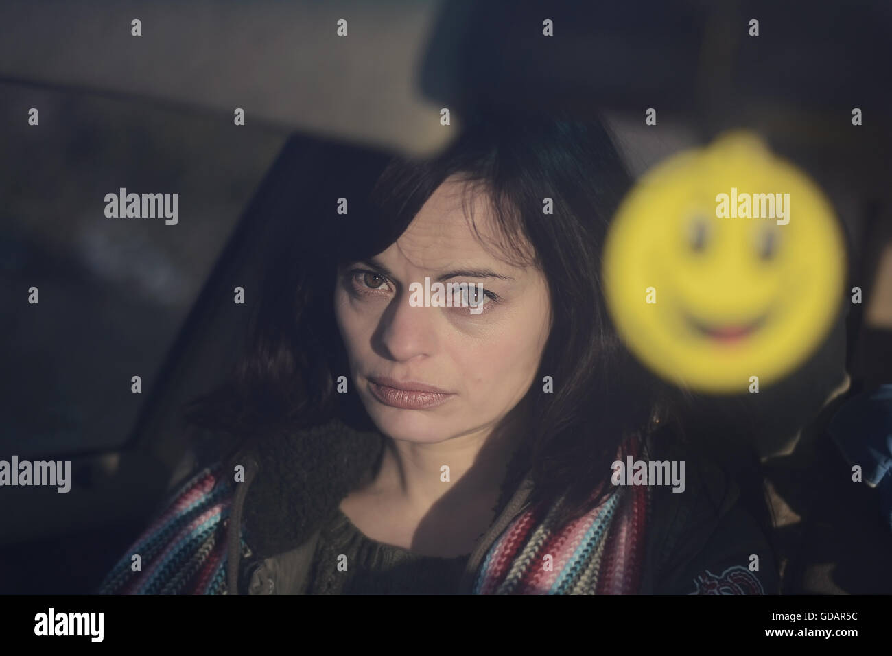 Femme triste en regardant par la fenêtre d'une voiture et d'une forme jaune sur le premier plan flou artistique. Des tons chaleureux ,vintage film comme regard . Banque D'Images