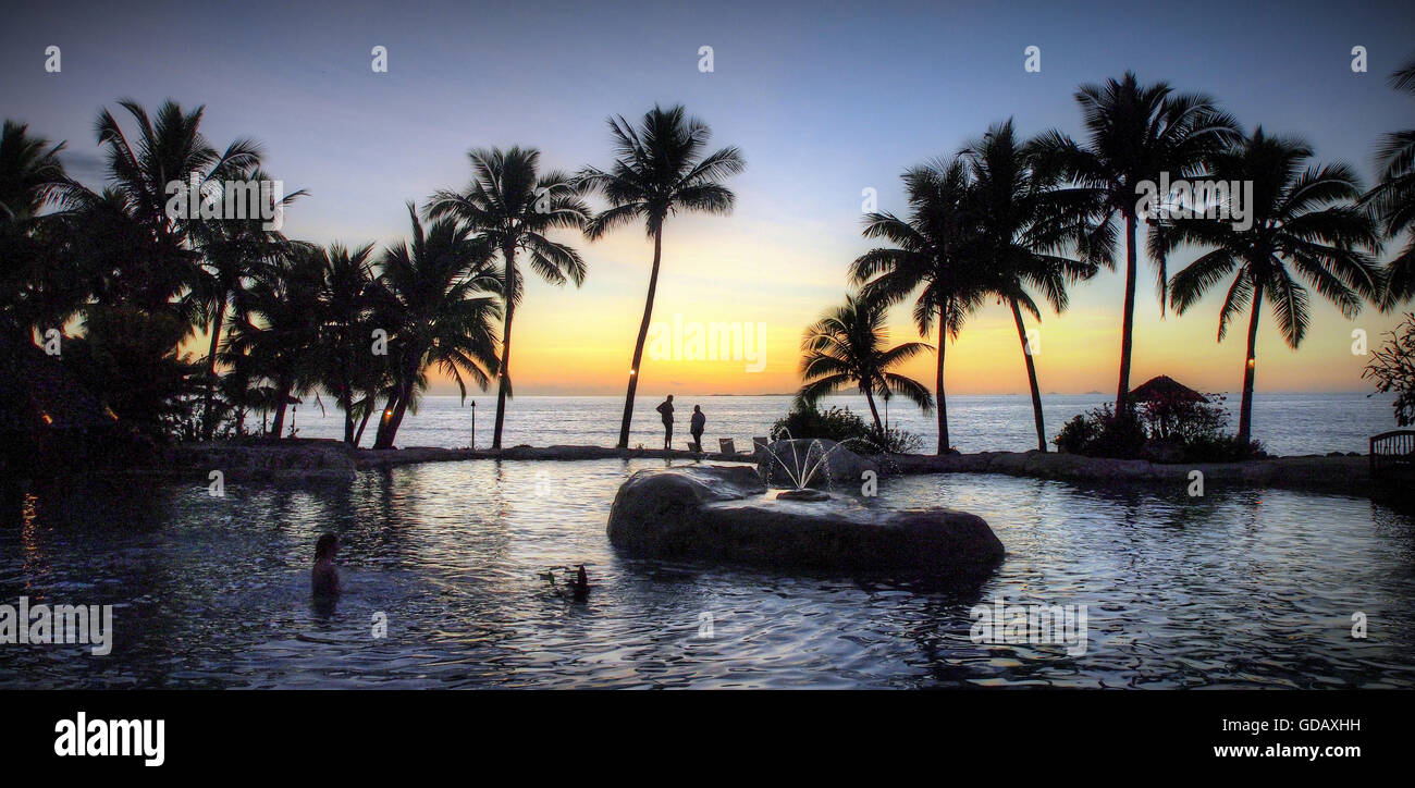 Sonaisali, Fidji, Pacifique Sud, le coucher du soleil, piscine, lumière arrière,palmiers,Romantical,humeur, piscine de l'hôtel,fontaine,personnes Banque D'Images