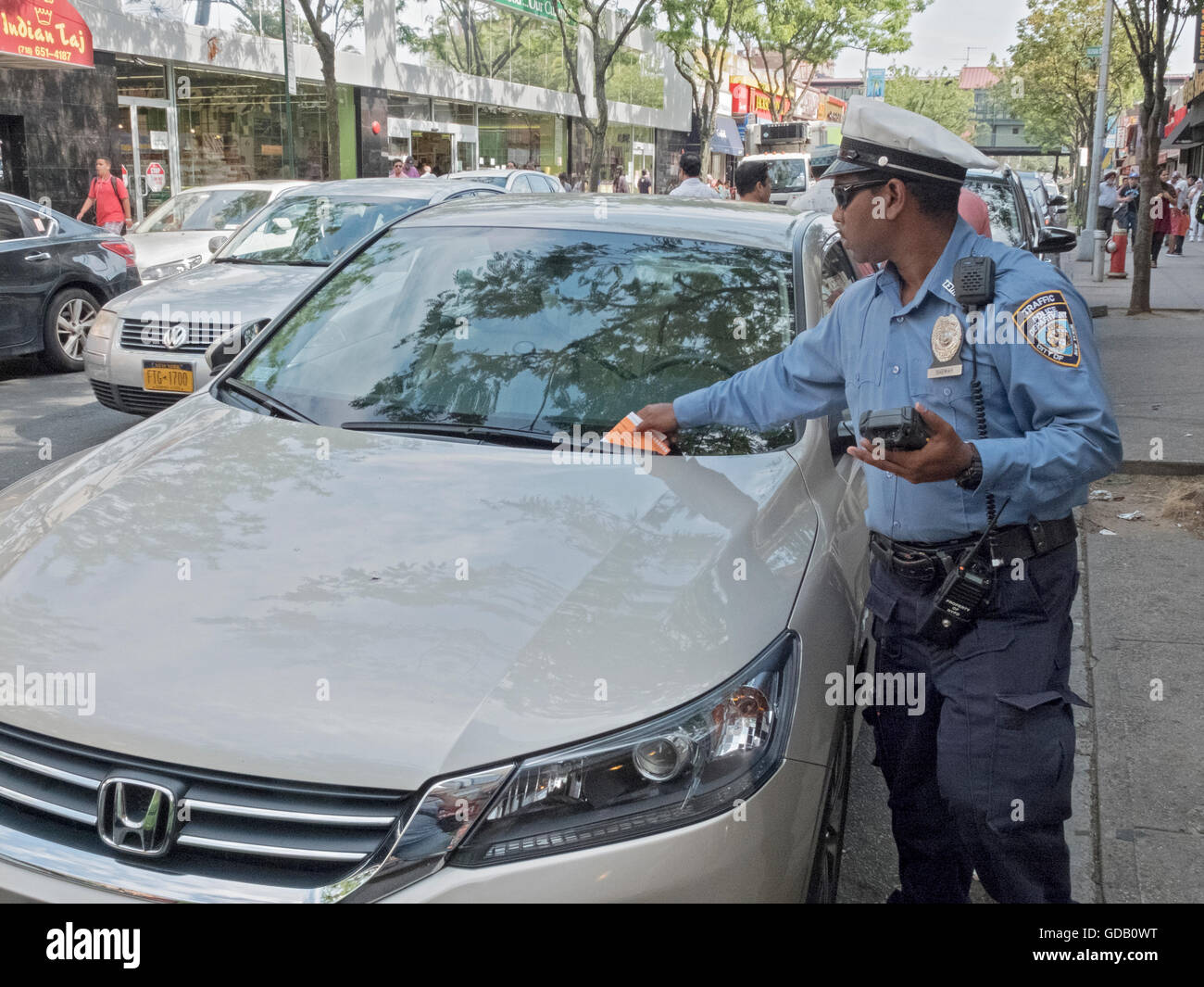 Un policier de la circulation de New York donne un billet pour le stationnement illégal à Jackson Heights, Queens, New York traffic cop, noir, Banque D'Images