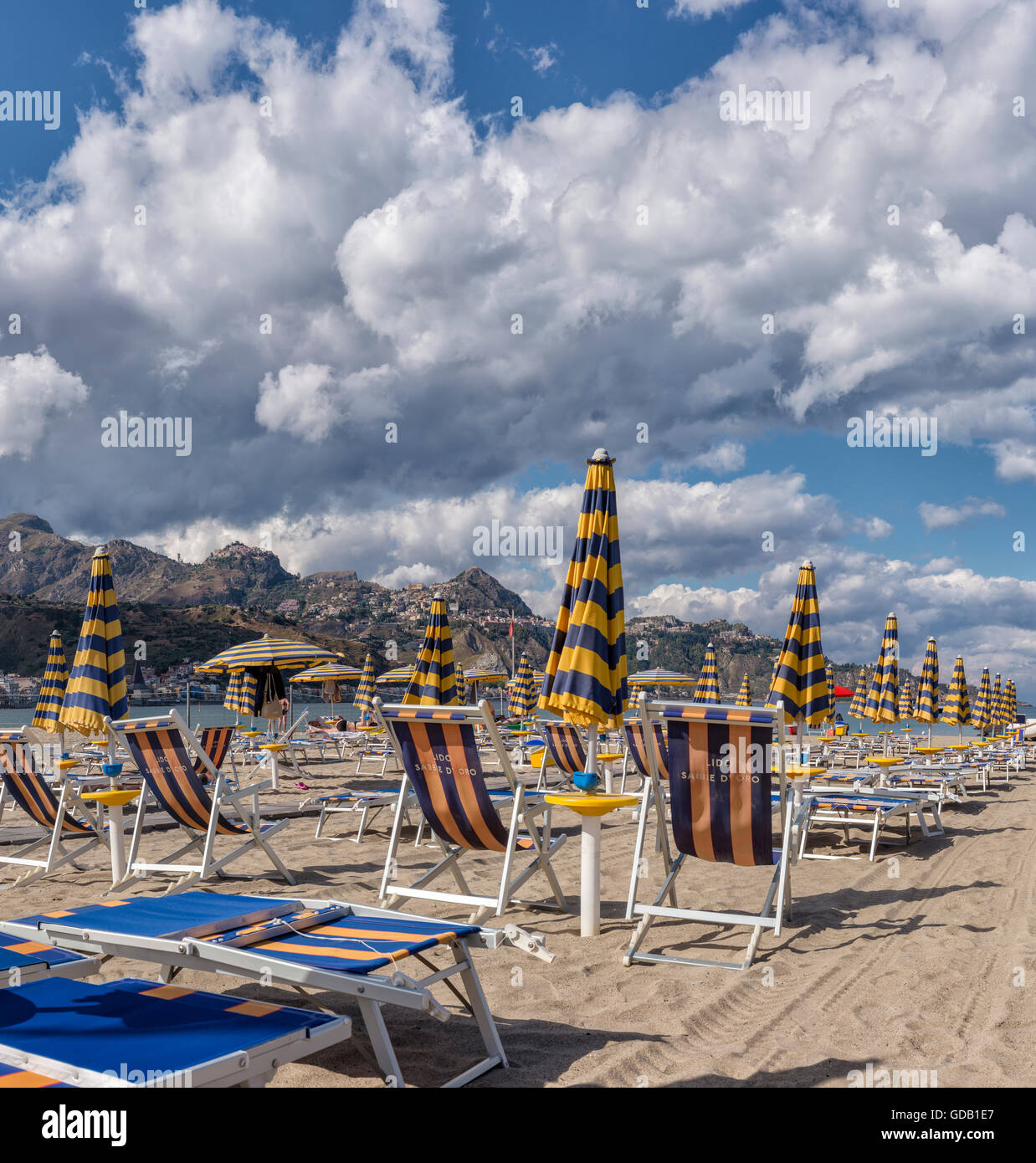 Chaises longues et parasols,vue vers Taormina sur une crête de montagne Banque D'Images