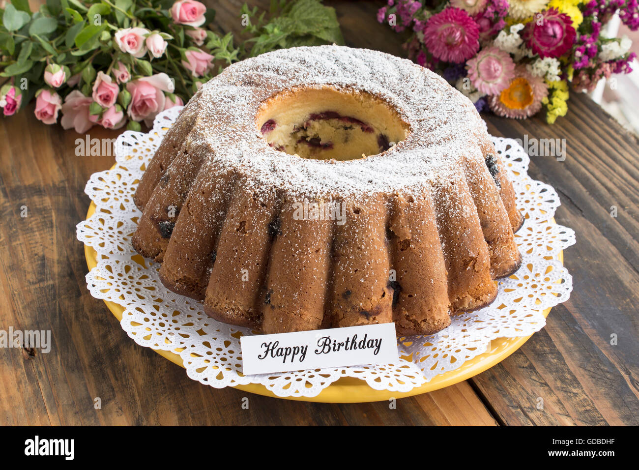 Joyeux Anniversaire Carte avec Kugelhopf et fleurs. Banque D'Images