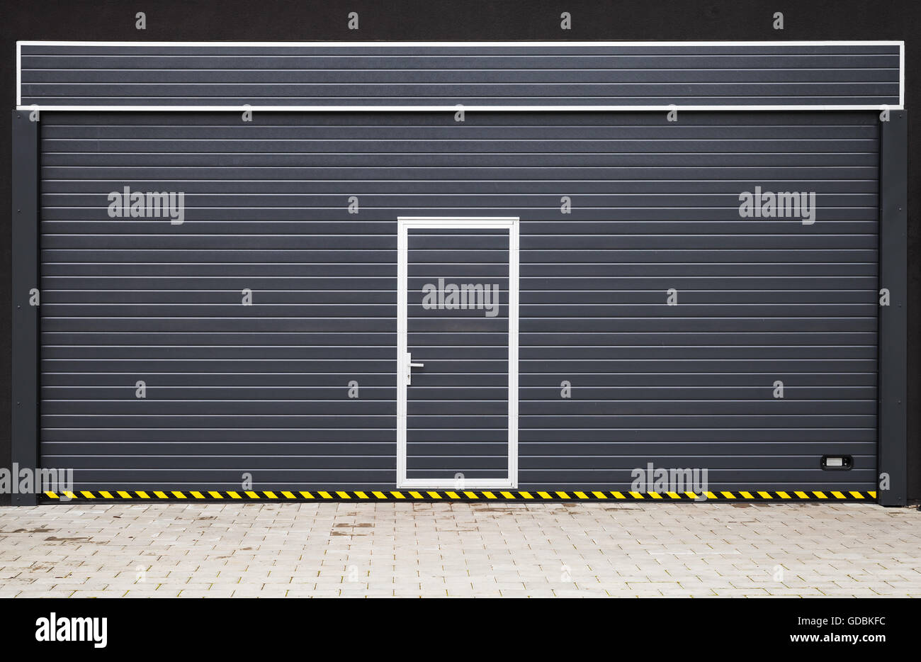 Porte de garage moderne gris foncé avec petite porte au milieu, la texture de fond photo Banque D'Images