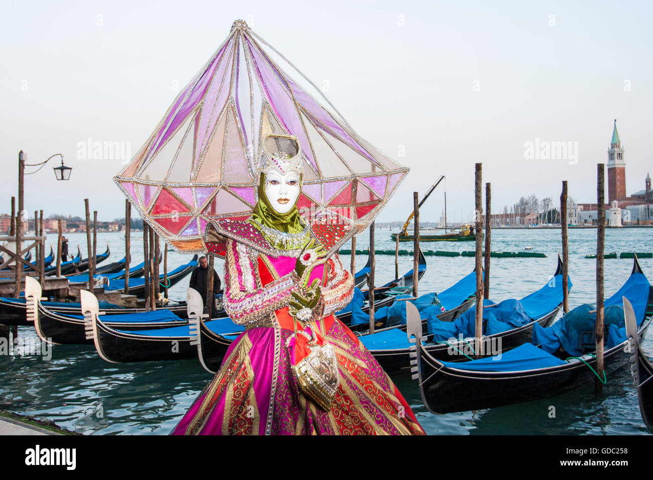 Femme en costume posant près des gondoles pour la photo dans Carnaval de Venise Banque D'Images