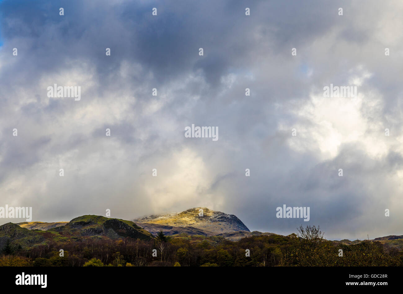 La lumière du soleil sur le Scafell Pike vu de l'Eskdale Valley dans le Lake District, Cumbria, Angleterre. Banque D'Images