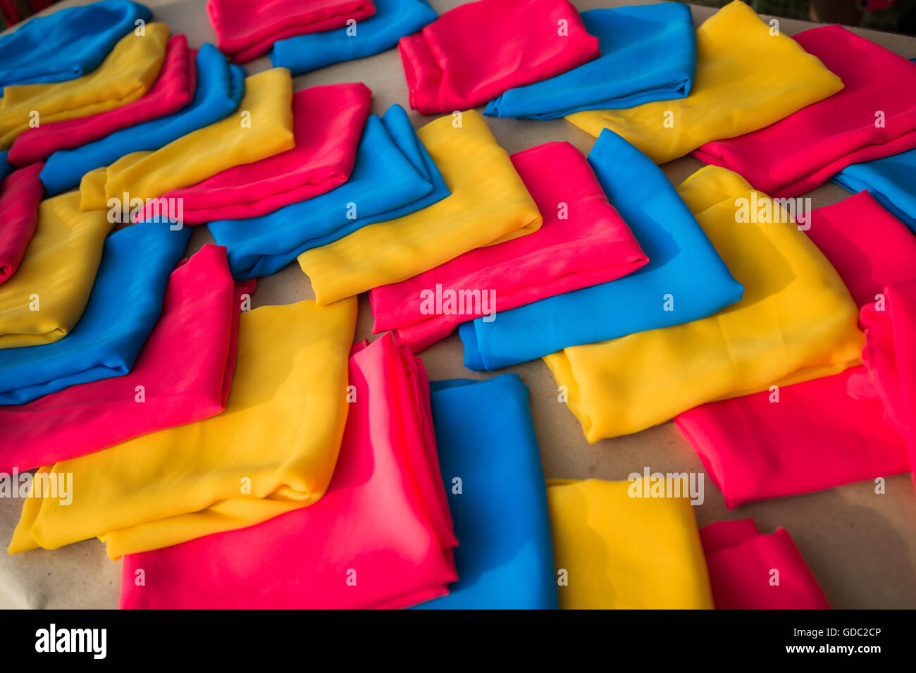 Pile de vêtements colorés ou des écharpes, on wooden table Banque D'Images