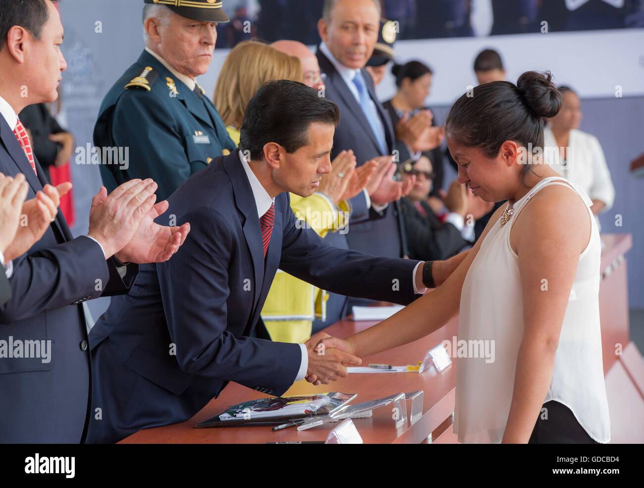 Le Président mexicain Enrique Pena Nieto réconforte l'épouse d'un policier fédéral tué après avoir présenté son avec l'Eagle Knight Award pour son mari au cours de la 88e anniversaire de la police nationale, le 13 juillet 2016 à Iztapalapa, Mexico, Mexique. Banque D'Images