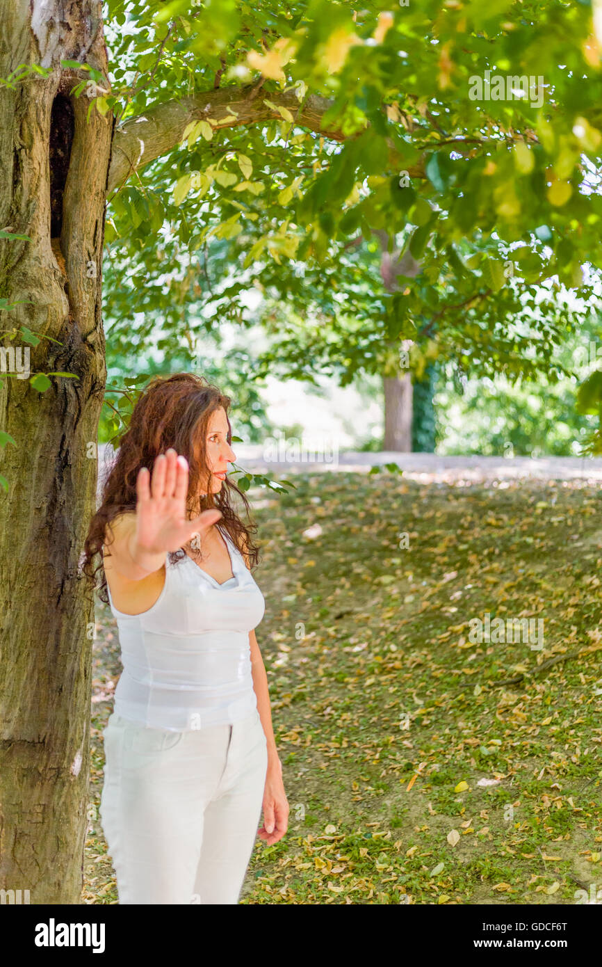 S'arrêter et parler à mon geste de la main par les bien plus de 40 femme avec des sentiments négatifs contre green garden background with copy space Banque D'Images