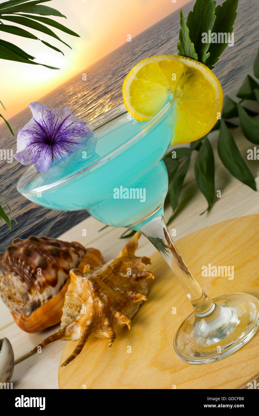 Cocktail bleu sur la mer fond coucher de soleil tropical. Margarita Blue Lagoon cocktail martini. Plage d'été boire de l'alcool. B glacé Banque D'Images