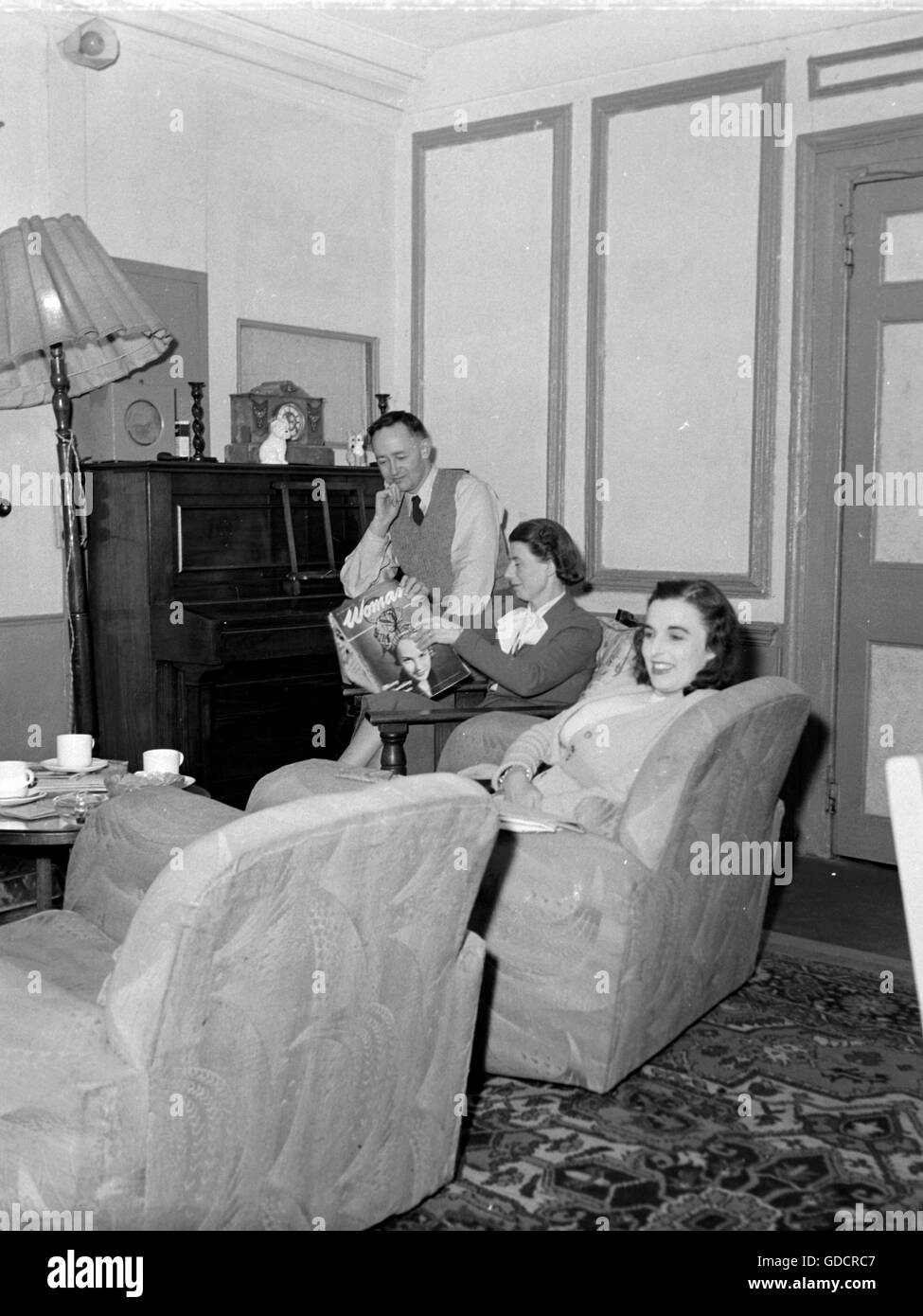 En général, une famille meublé salon c1950. Mère est la lecture 'Femme Magazine'. Photographie par Tony Henshaw Banque D'Images