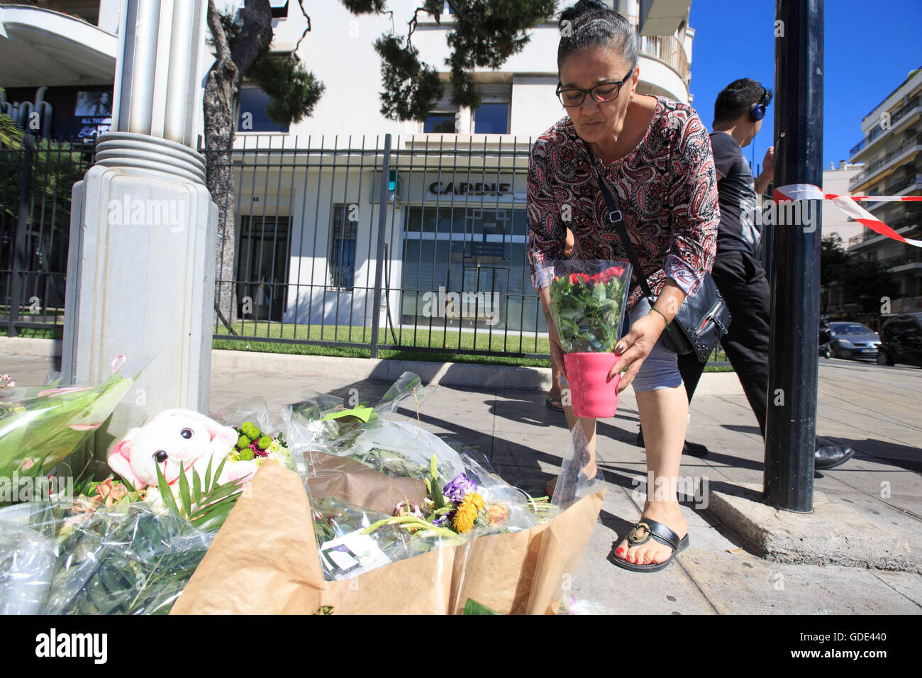 Nice, France. 16 juillet, 2016. Une femme offre des fleurs pour les victimes de l'attaque terroriste de la Promenade des Anglais à Nice, France, le 16 juillet 2016. L'État islamique (est) de l'agence de presse liés à l'AMAQ a revendiqué la responsabilité de l'attaque à Nice le jeudi qui a tué 84 personnes, ont rapporté les médias français. Credit : Xu Jinquan/Xinhua/Alamy Live News Banque D'Images