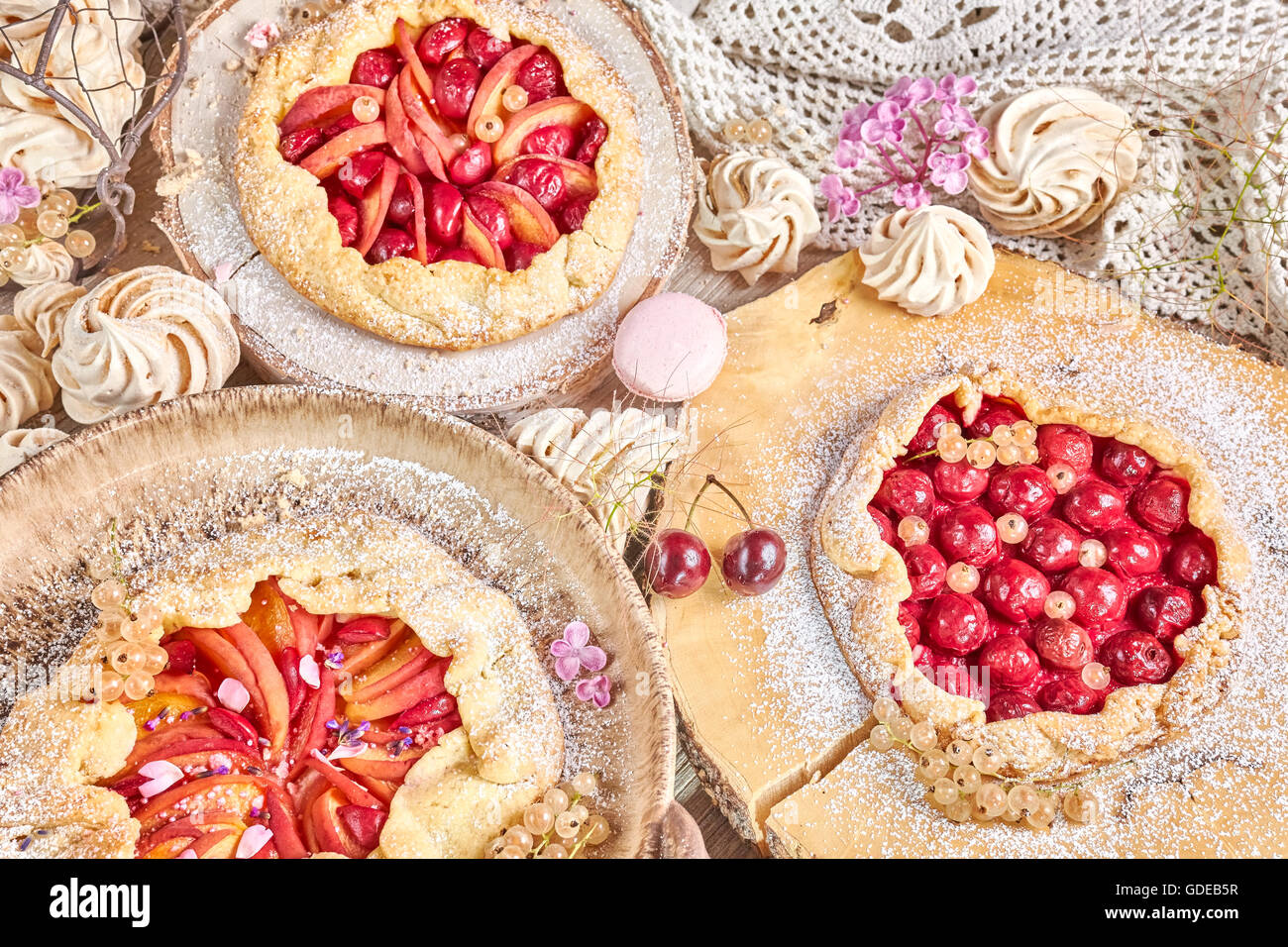 Des tartes aux fruits et meringues rustiques, pâtisserie maison, couleurs pastel. Banque D'Images