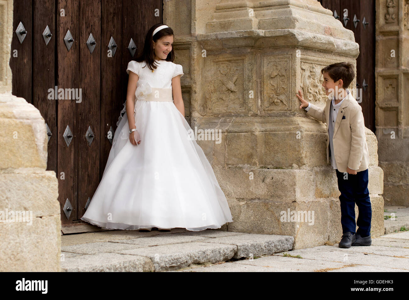 Fille et garçon à l'extérieur de l'église avant la première communion Banque D'Images