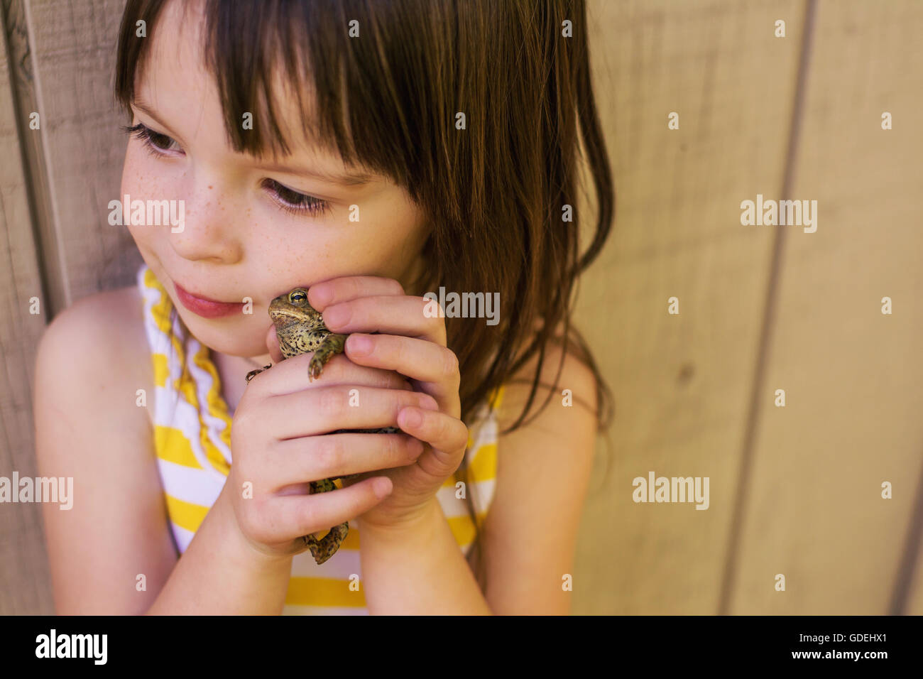 Girl holding une grenouille à côté de son visage Banque D'Images