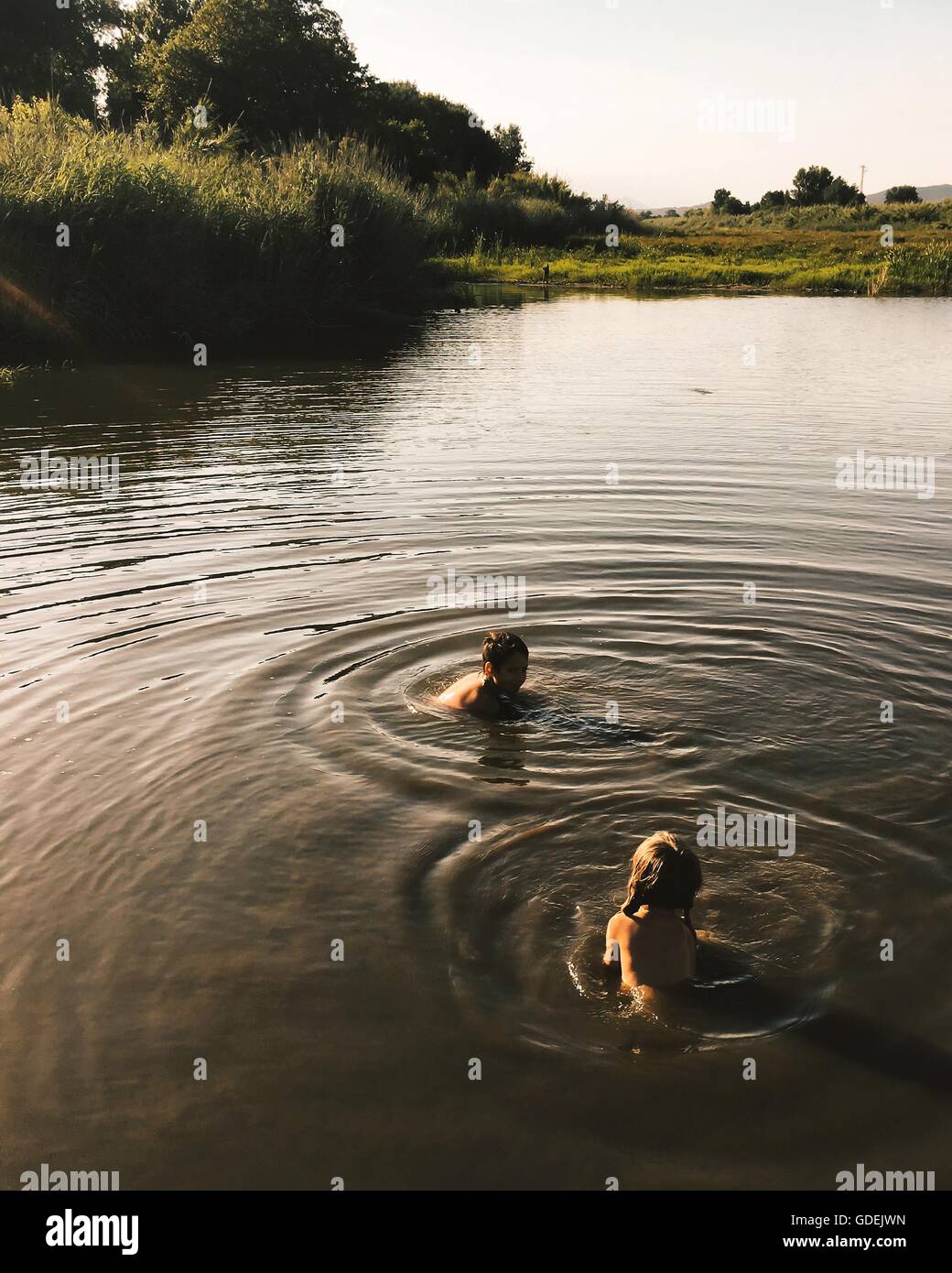Boy and girl swimming in river Banque D'Images