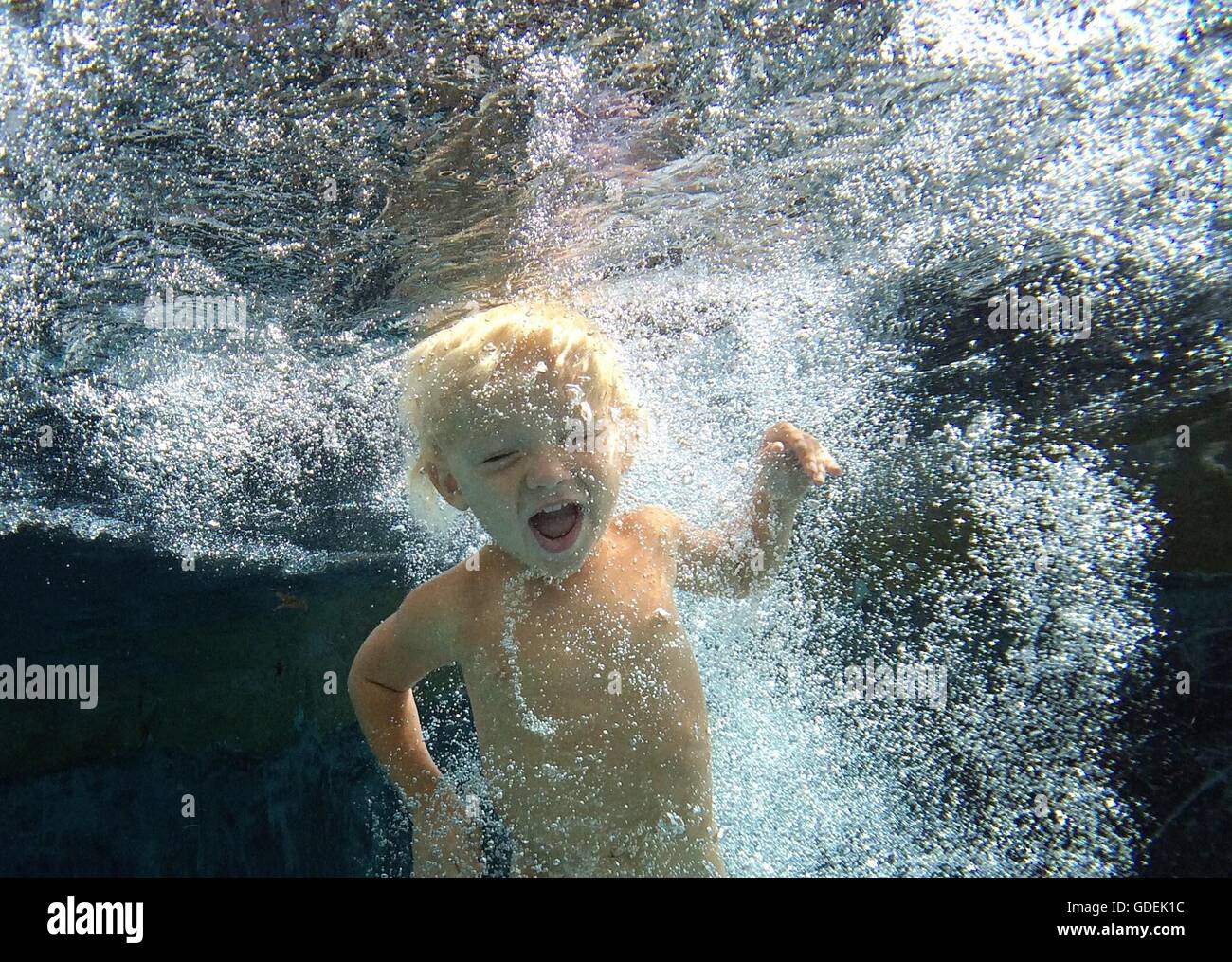 Boy swimming underwater in swimming pool Banque D'Images