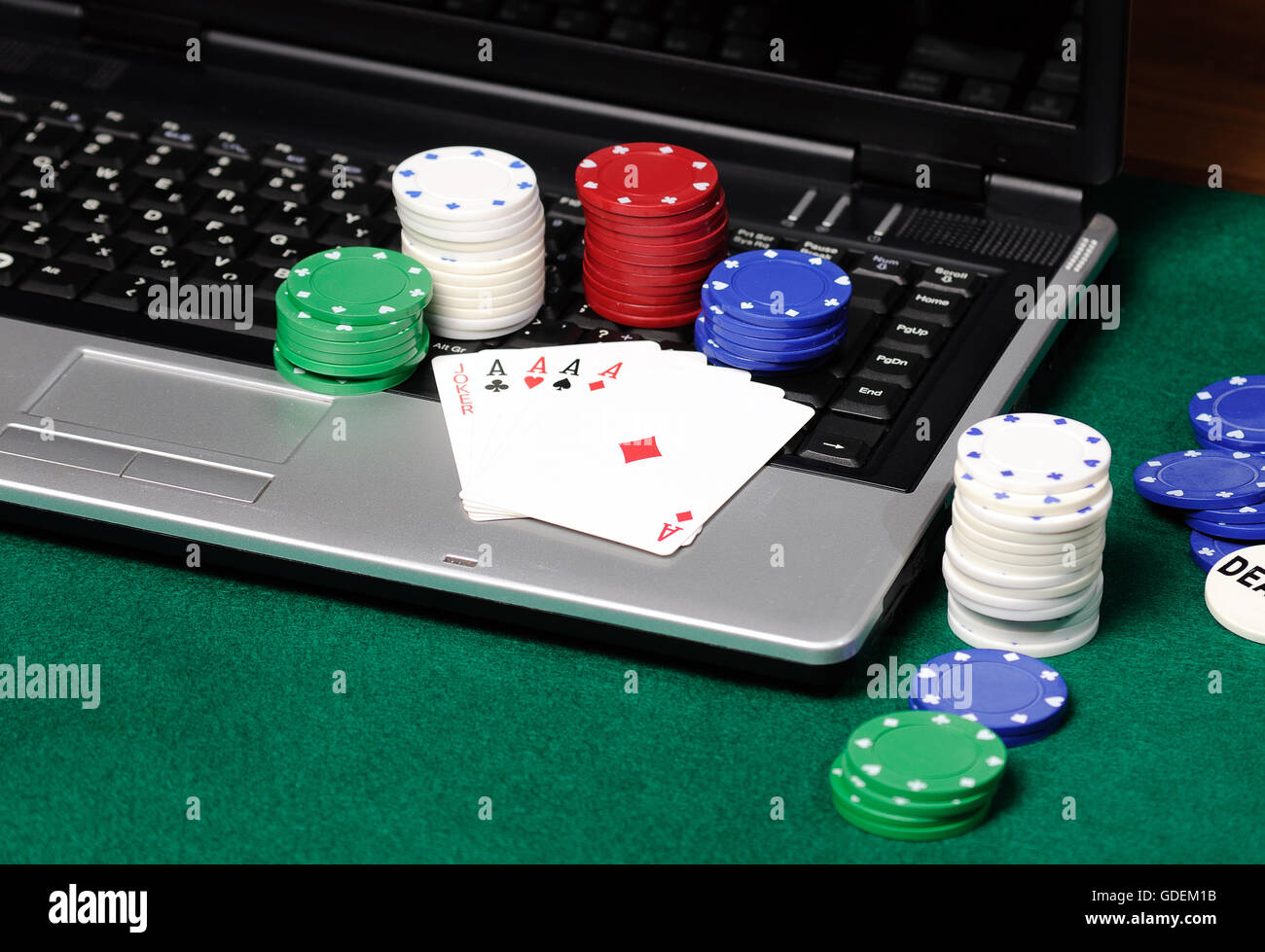 Des jetons et cartes de poker sur un ordinateur portable Banque D'Images