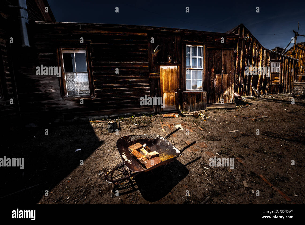 Brouette ancienne avec des briques en face de maisons à Bodie ville minière California USA Banque D'Images