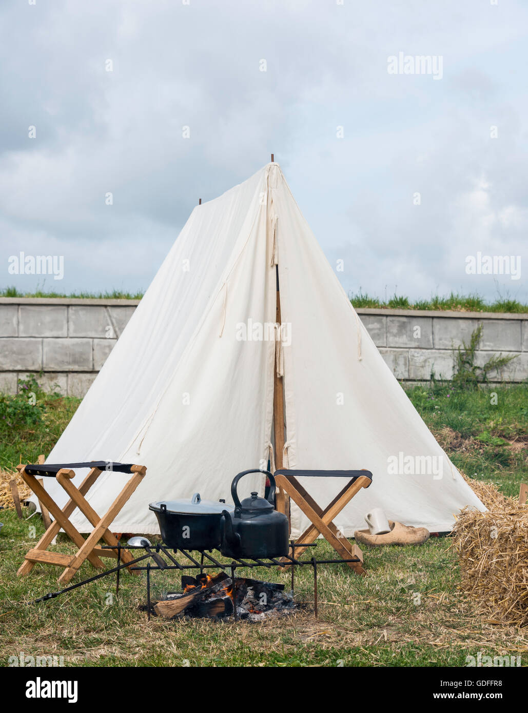 Tente sur le camping avec le feu et de matériel de cuisine et deux chaises  pliantes en bois Photo Stock - Alamy