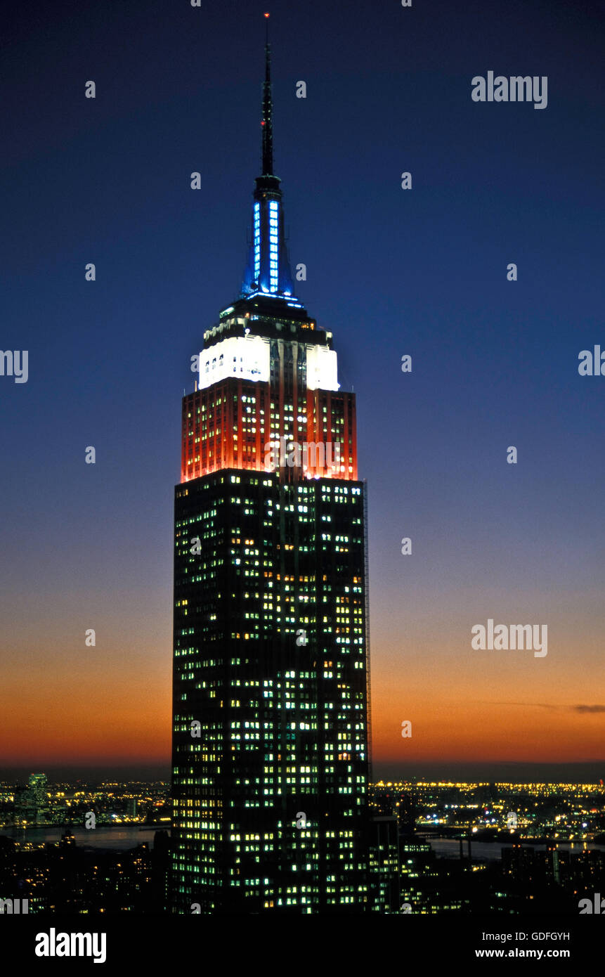 Statue de l'Empire Building allumé en rouge, blanc et bleu, Crépuscule, NYC, USA Banque D'Images