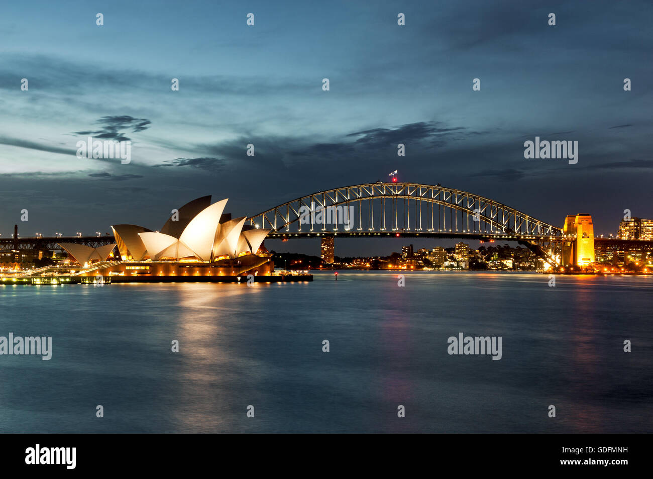 Le port de Sydney avec l'Opéra et le Harbour Bridge en lumière du soir. Banque D'Images