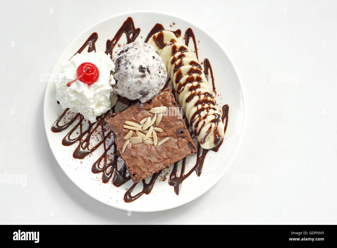 Brownie au chocolat avec crème glacée banane et cerise sur le gâteau Banque D'Images
