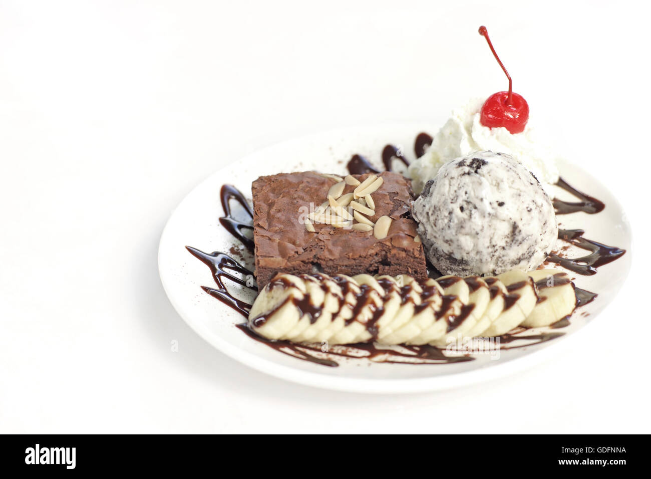Brownie au chocolat avec crème glacée banane et cerise sur top isolé sur fond blanc Banque D'Images