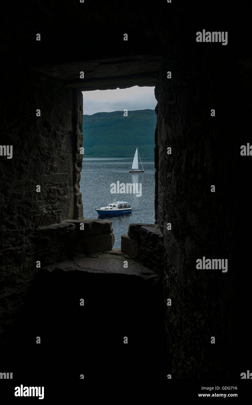 Vue sur le Loch Ness d'Urquhart Castle. Un voilier et un bateau à moteur et sur le loch. Banque D'Images