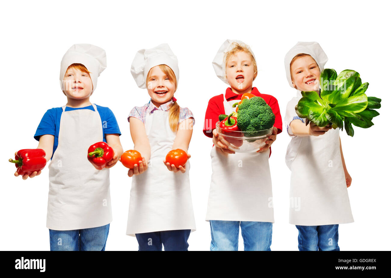 Les enfants en uniforme de cook holding fresh vegetables Banque D'Images
