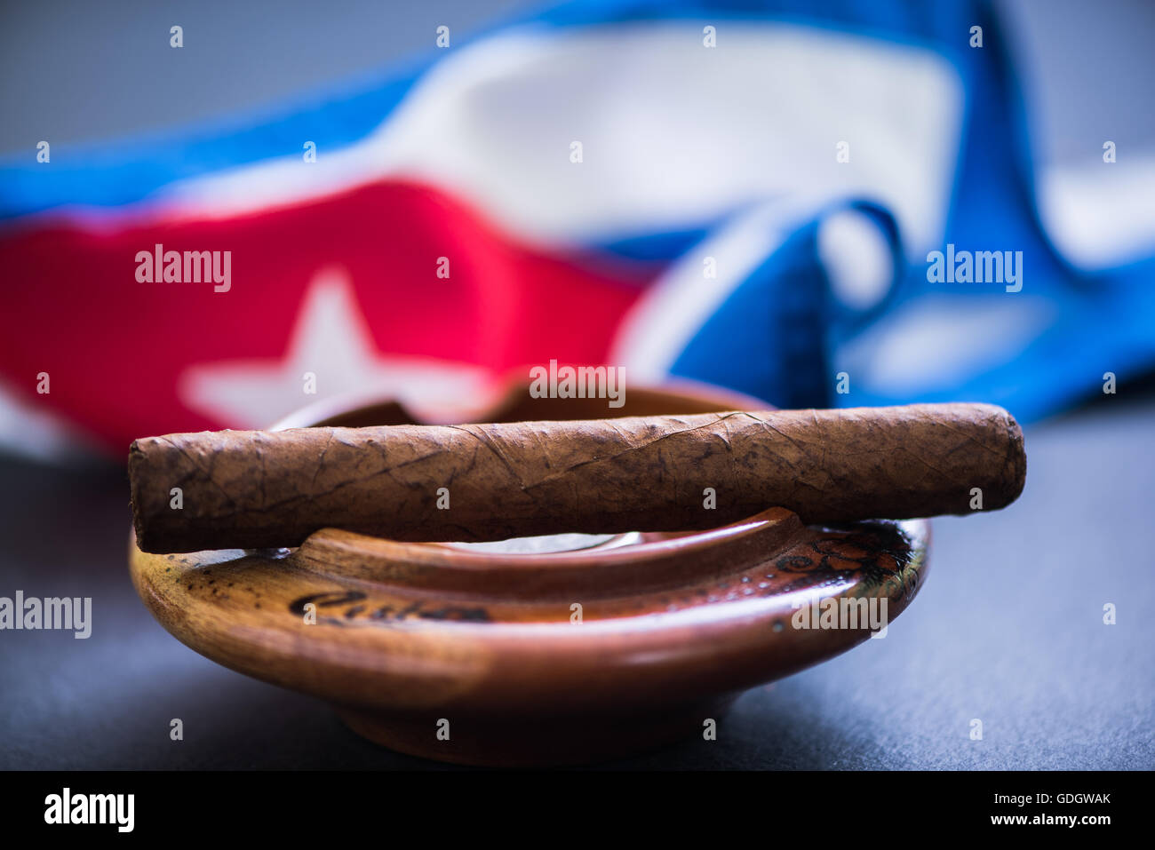 Cigare cubain en cendrier et drapeau cubain Banque D'Images