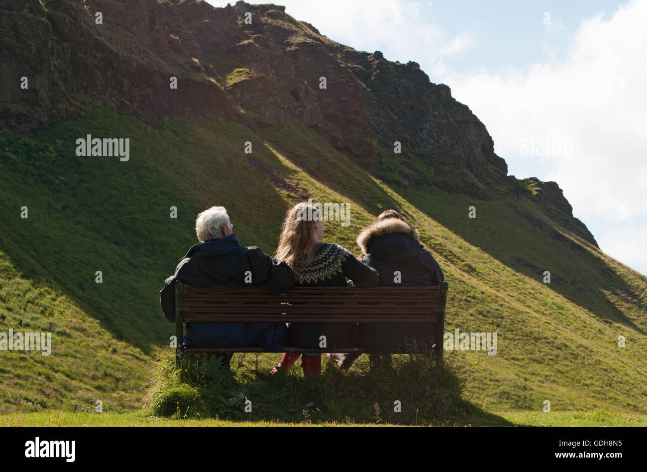 L'Islande, le nord de l'Europe : une famille islandaise assis sur un banc dans la campagne près de Seljalandsfoss, l'une des plus célèbres cascades islandaise Banque D'Images