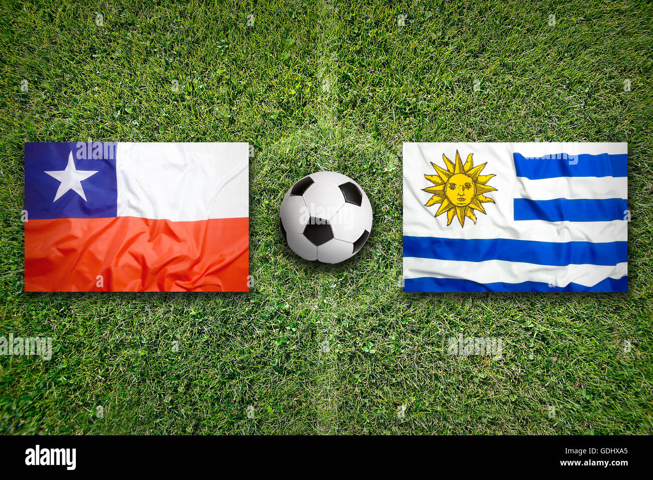 Le Chili et l'Uruguay les drapeaux sur le terrain de soccer vert Banque D'Images