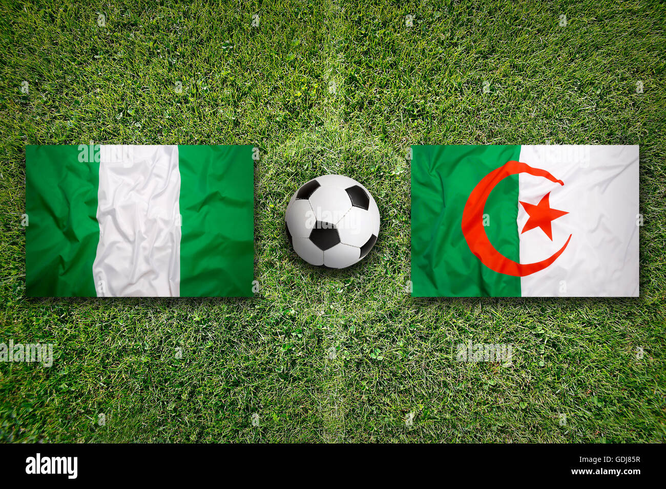 Nigéria contre l'Algérie les drapeaux sur le terrain de soccer vert Banque D'Images