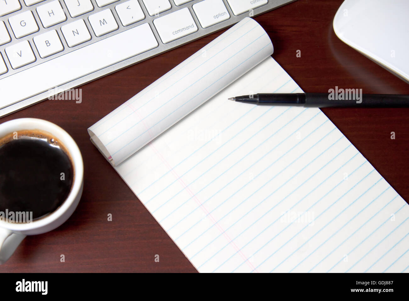 Le bloc-notes de bureau vierge sur un bureau en bois avec clavier et café- ajouter votre propre message sur le papier Banque D'Images