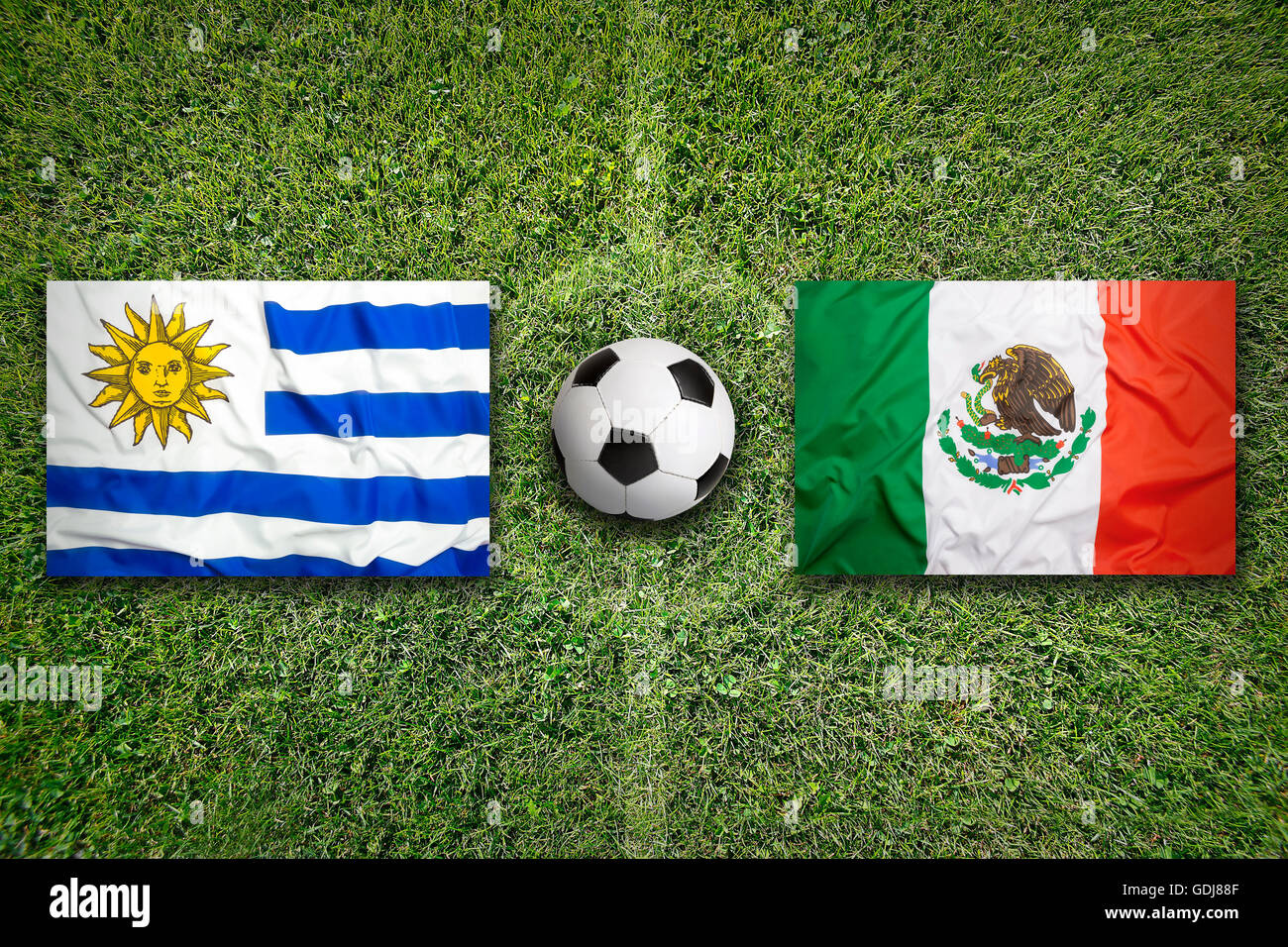 L'Uruguay vs Mexique Les drapeaux sur le terrain de soccer vert Banque D'Images