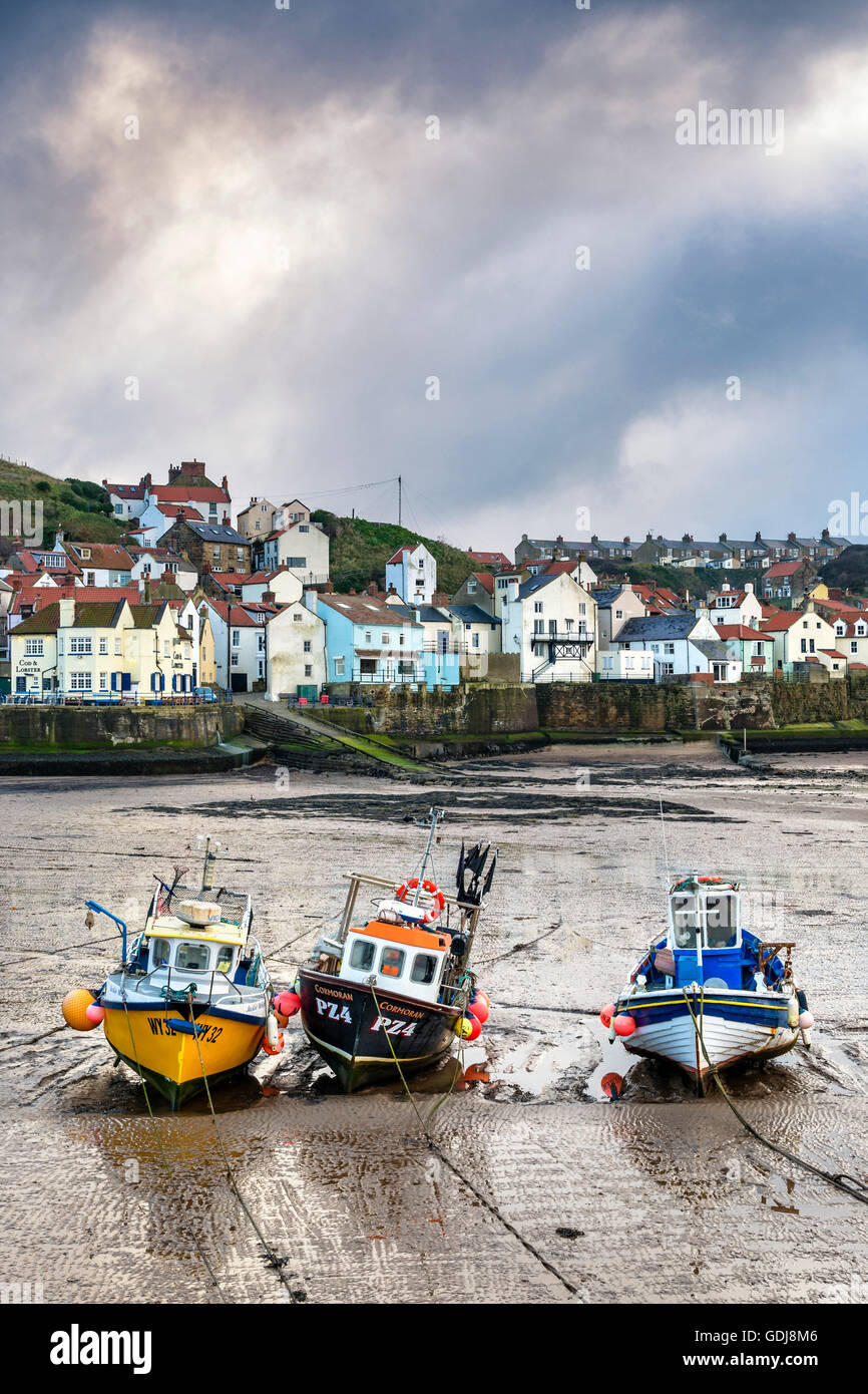 Bateaux de pêche bordée d'affilée à marée basse dans le port de Staithes Banque D'Images