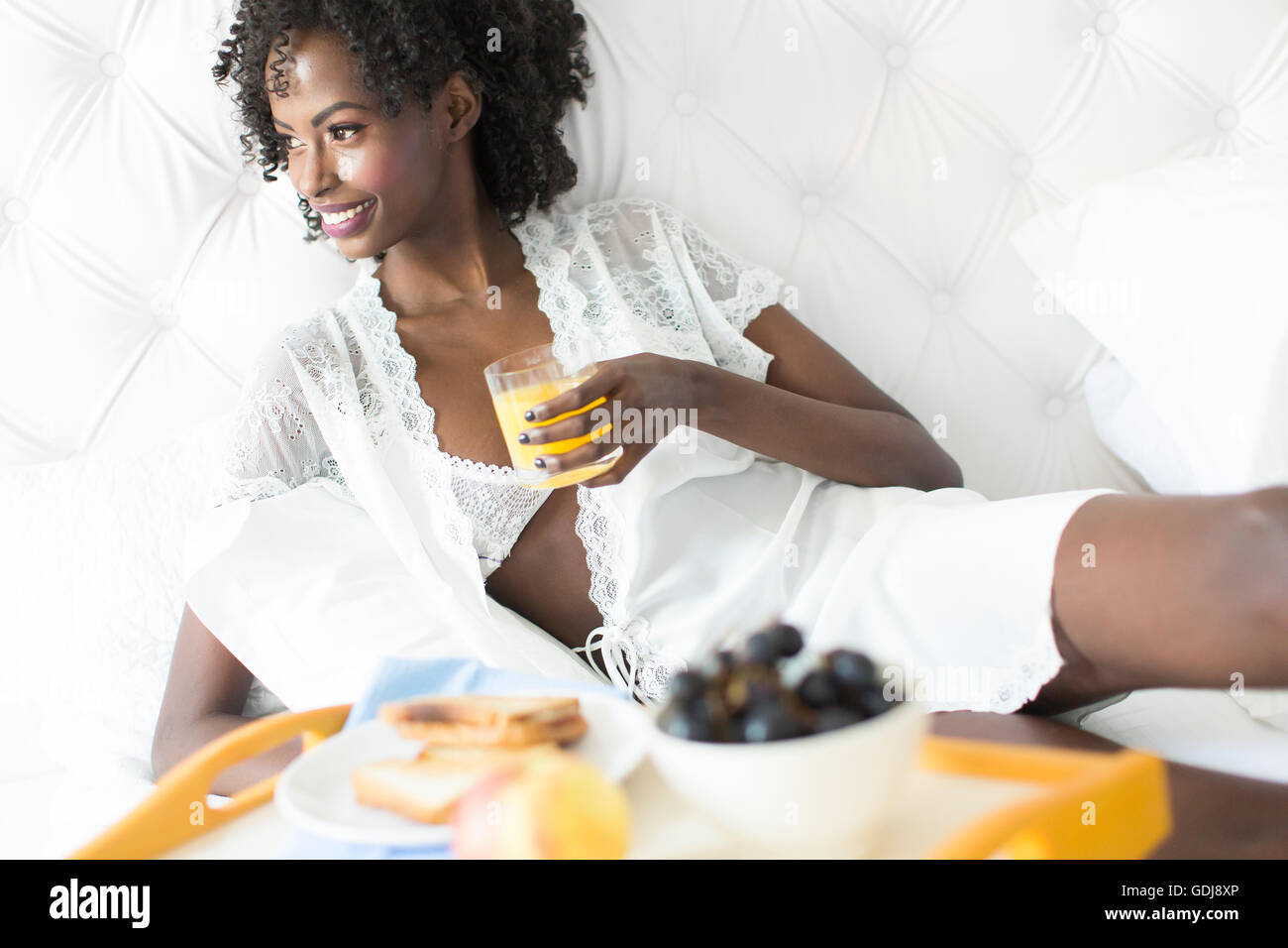 African American Woman in white sur le lit Banque D'Images
