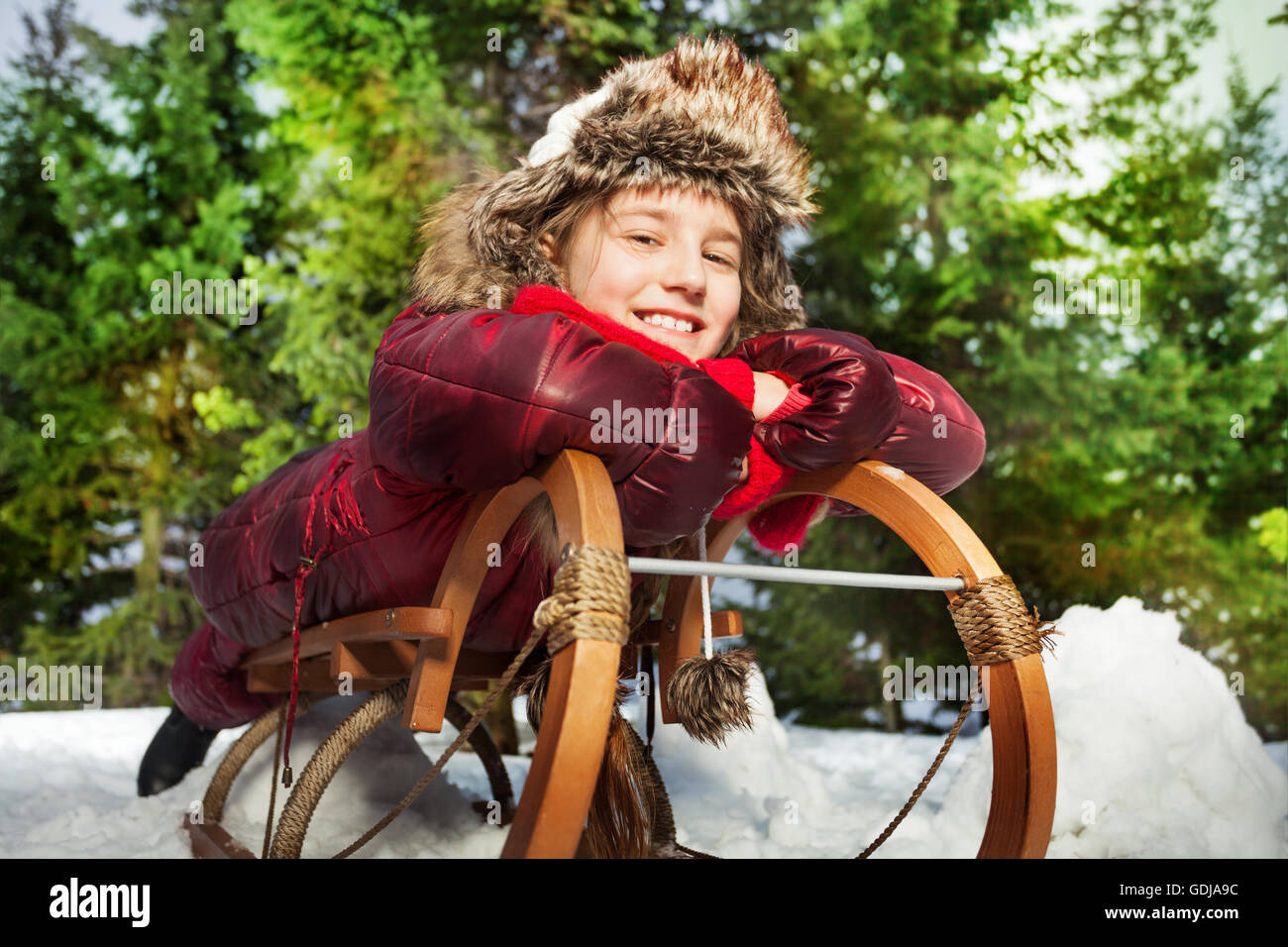 Smiling girl having fun in hiver neige sur un traîneau Banque D'Images