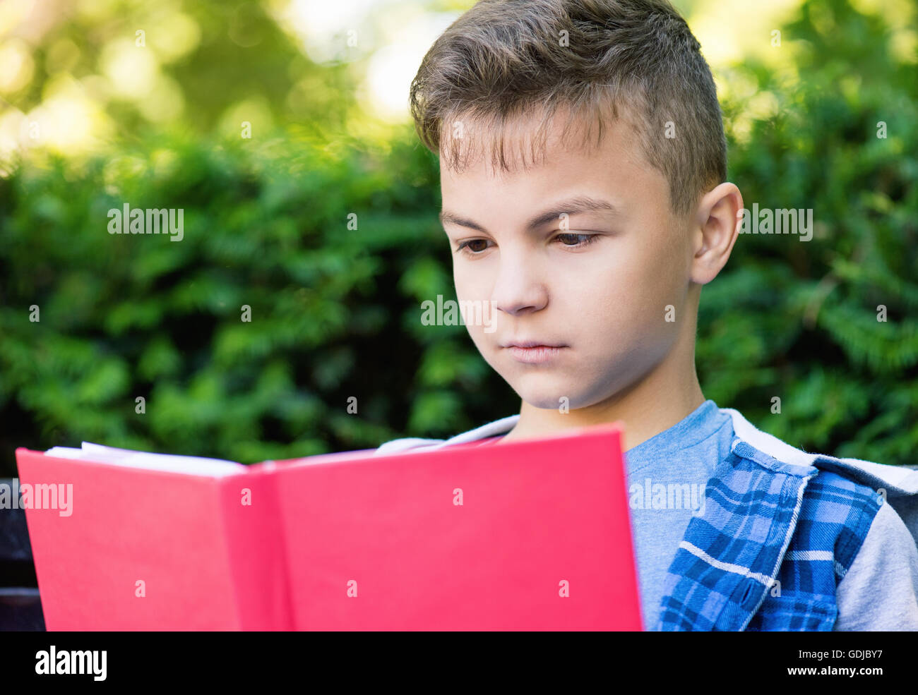 Teen boy reading book Banque D'Images