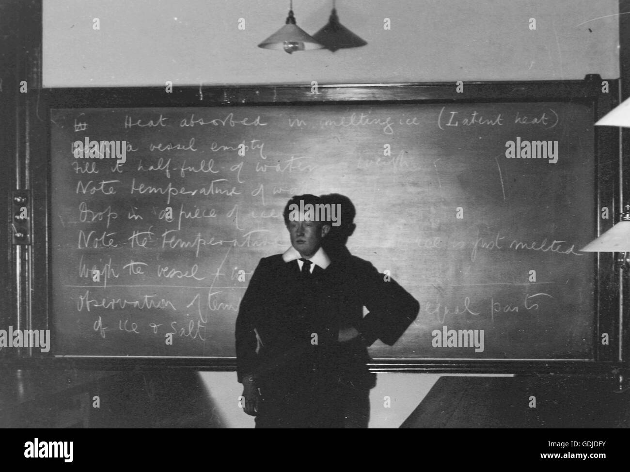 Garçon de l'école en face de l'ardoise sur leçon instructions pour une classe de science ou de chimie c1913. Photo par Tony Henshaw Banque D'Images