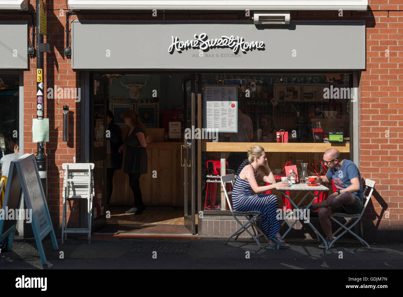 Un couple de prendre un verre à l'extérieur Home Sweet Home situé sur le bord de la rue du Nord, domaine de Manchester. Banque D'Images